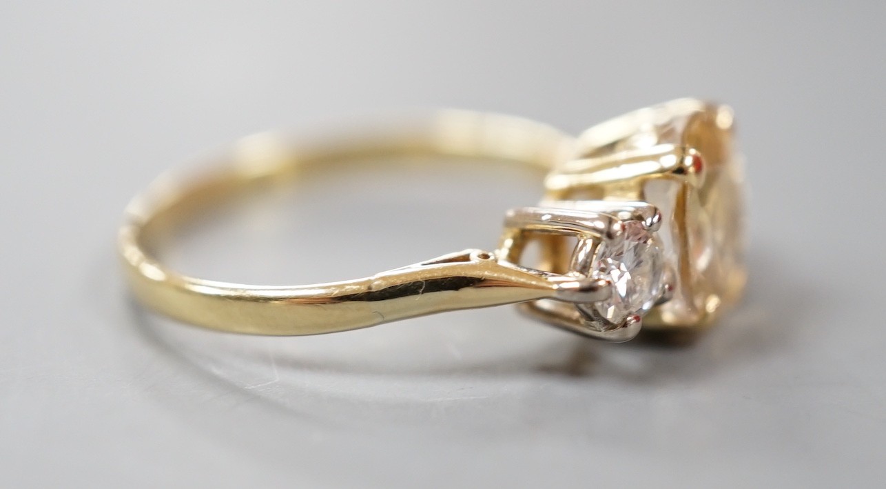 A yellow metal, singe stone oval cut yellow sapphire and two stone round cut diamond set ring, size N/O, gross weight 2.9 grams.